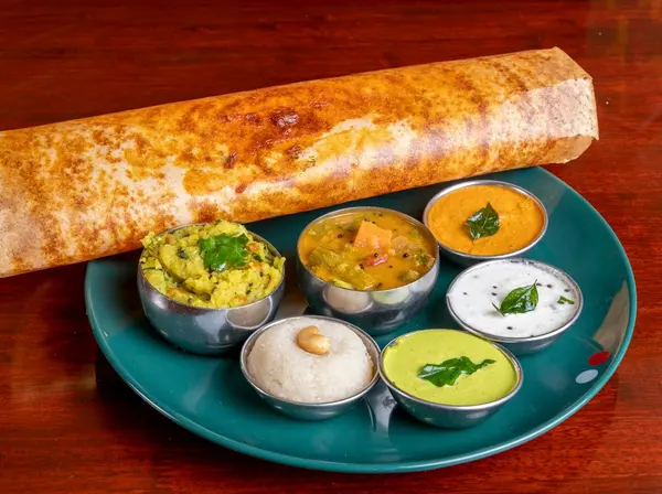 A dosa breakfast with chutneys and sambar