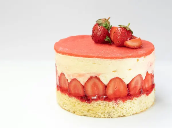 A strawberry mousse cake topped with fresh strawberries